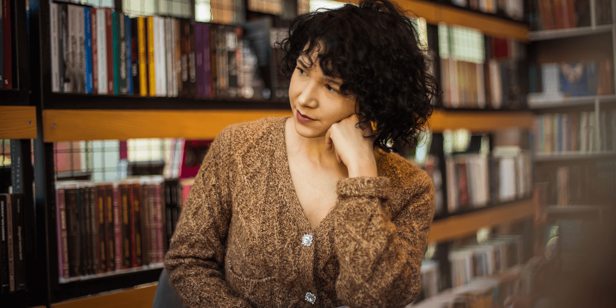 Frau in der Bibliothek, die ein Buch liest.